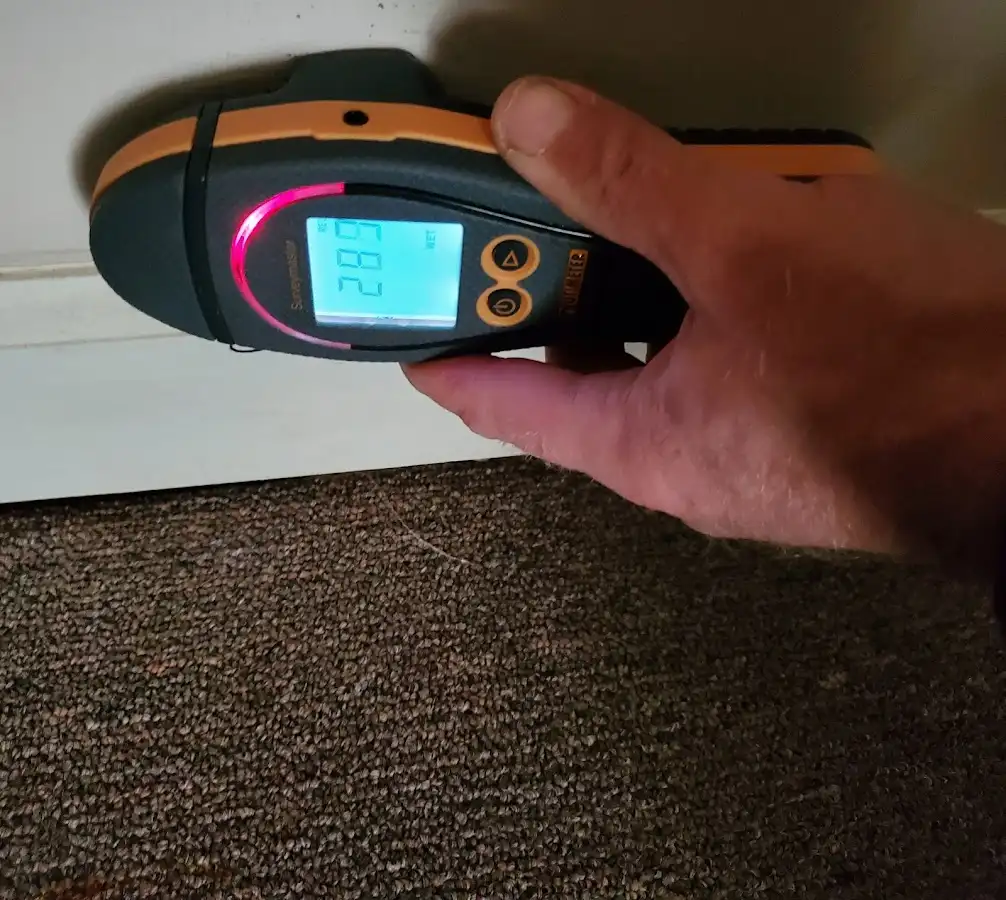Moisture detection at baseboard during Storm Damage Restoration in Burlington